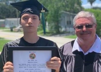 Picure of Thomas and a instructor holidng his diploma