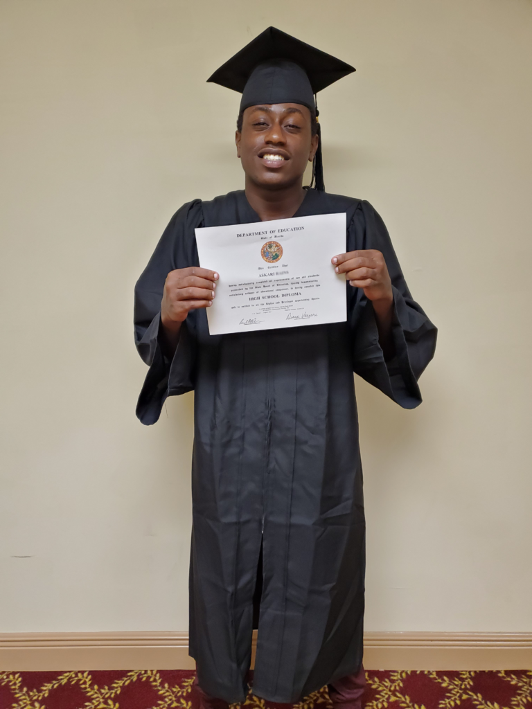 Askari smiling with his diploma
